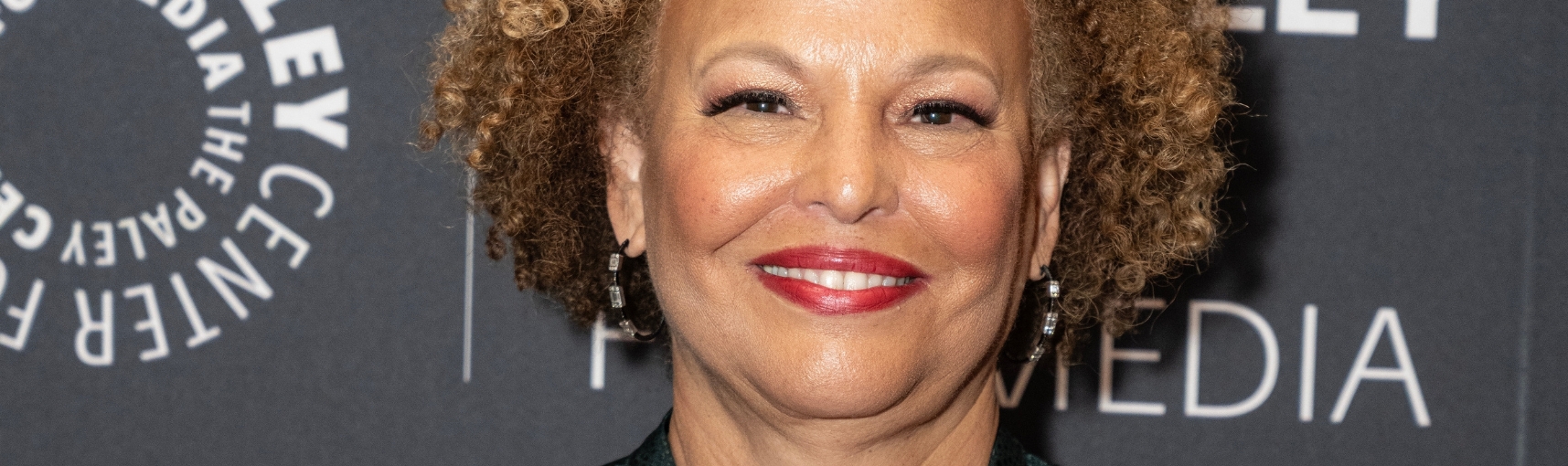 A close up photo of a light-skinned Black woman wearing red lipstick